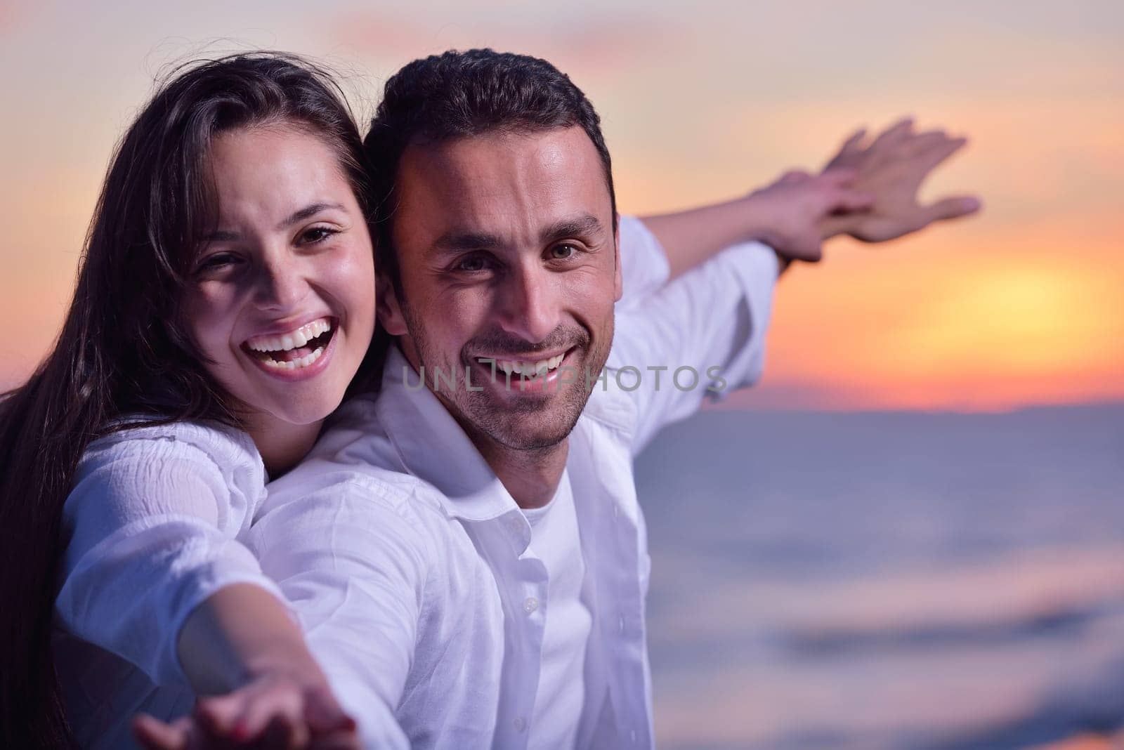 happy young romantic couple in love have fun on beautiful beach at beautiful summer day