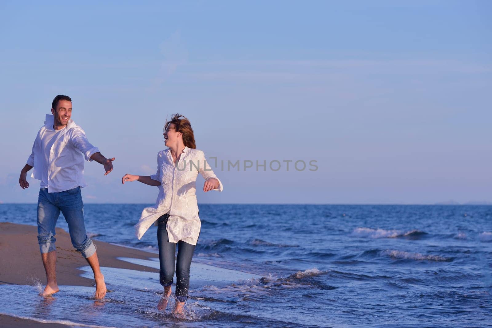 happy young romantic couple in love have fun on beautiful beach at beautiful summer day