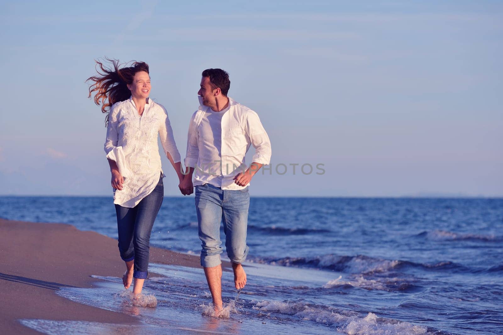 happy young romantic couple in love have fun on beautiful beach at beautiful summer day