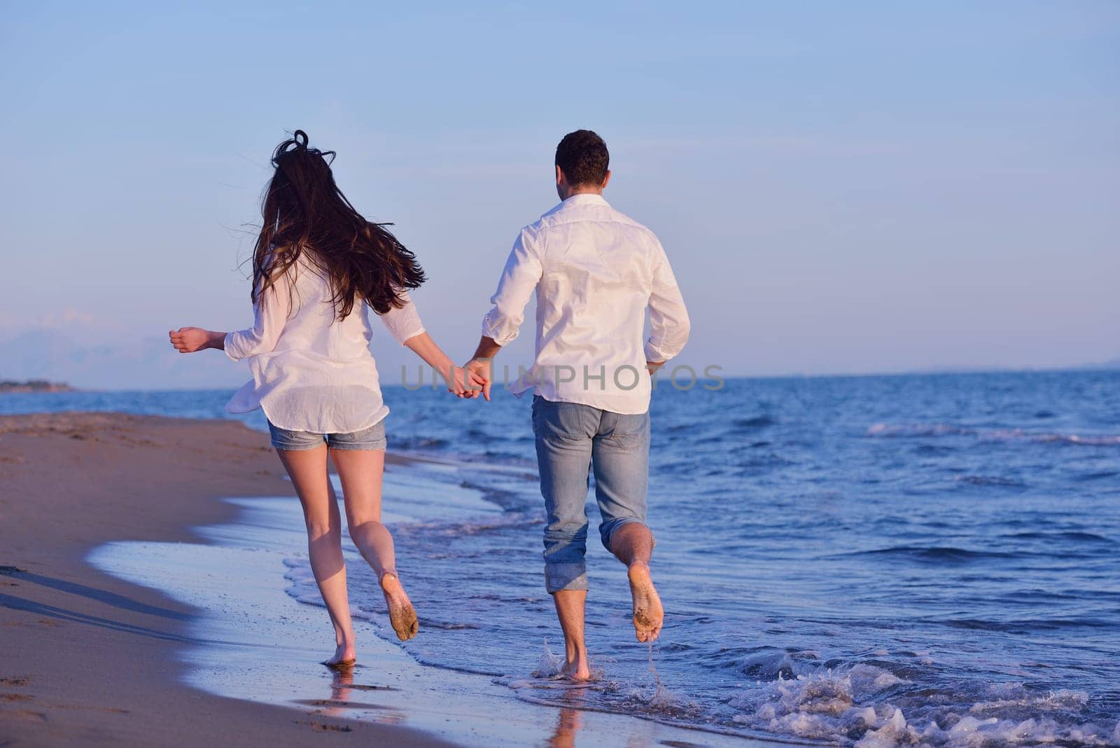 happy young romantic couple in love have fun on beautiful beach at beautiful summer day