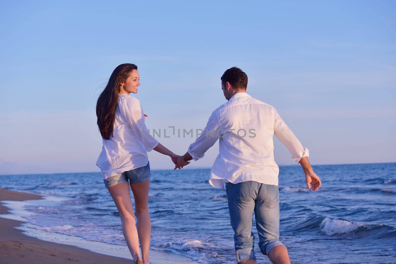 happy young romantic couple in love have fun on beautiful beach at beautiful summer day