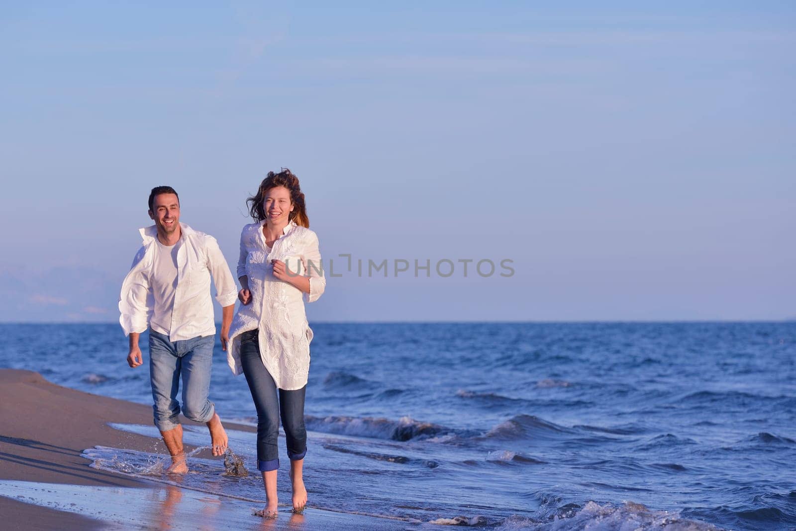 happy young romantic couple in love have fun on beautiful beach at beautiful summer day