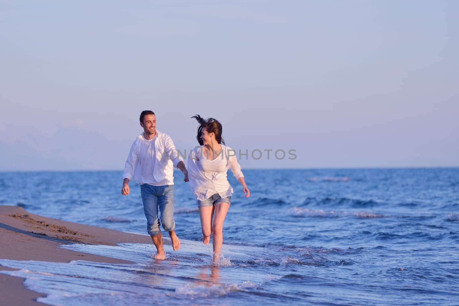happy young romantic couple in love have fun on beautiful beach at beautiful summer day