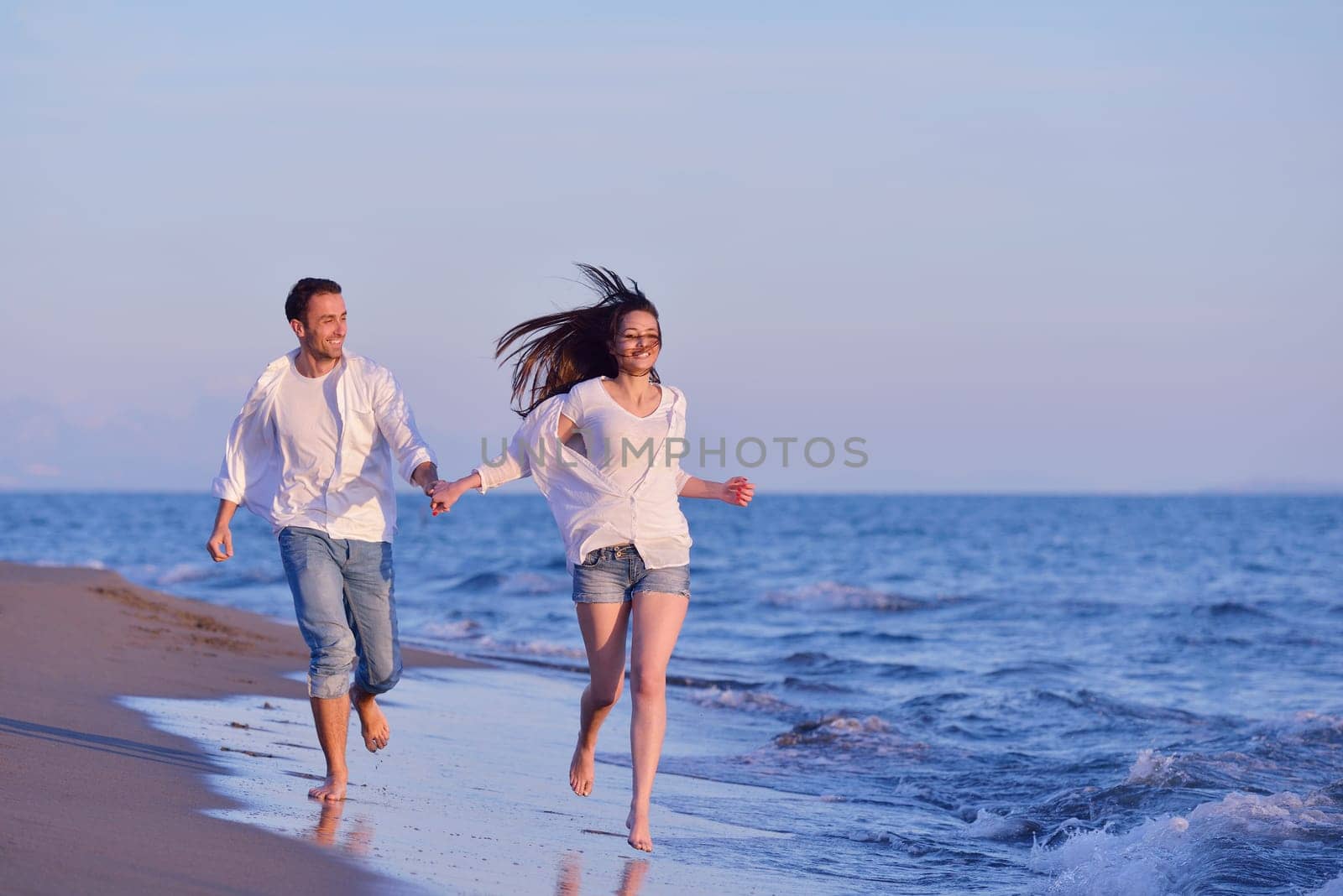 happy young romantic couple in love have fun on beautiful beach at beautiful summer day