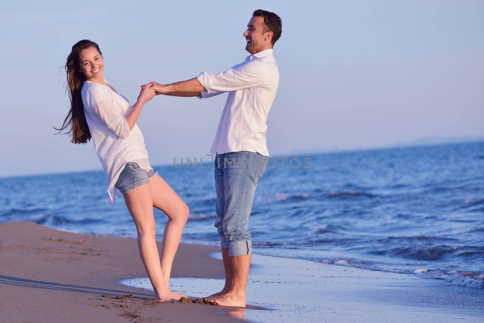 happy young romantic couple in love have fun on beautiful beach at beautiful summer day