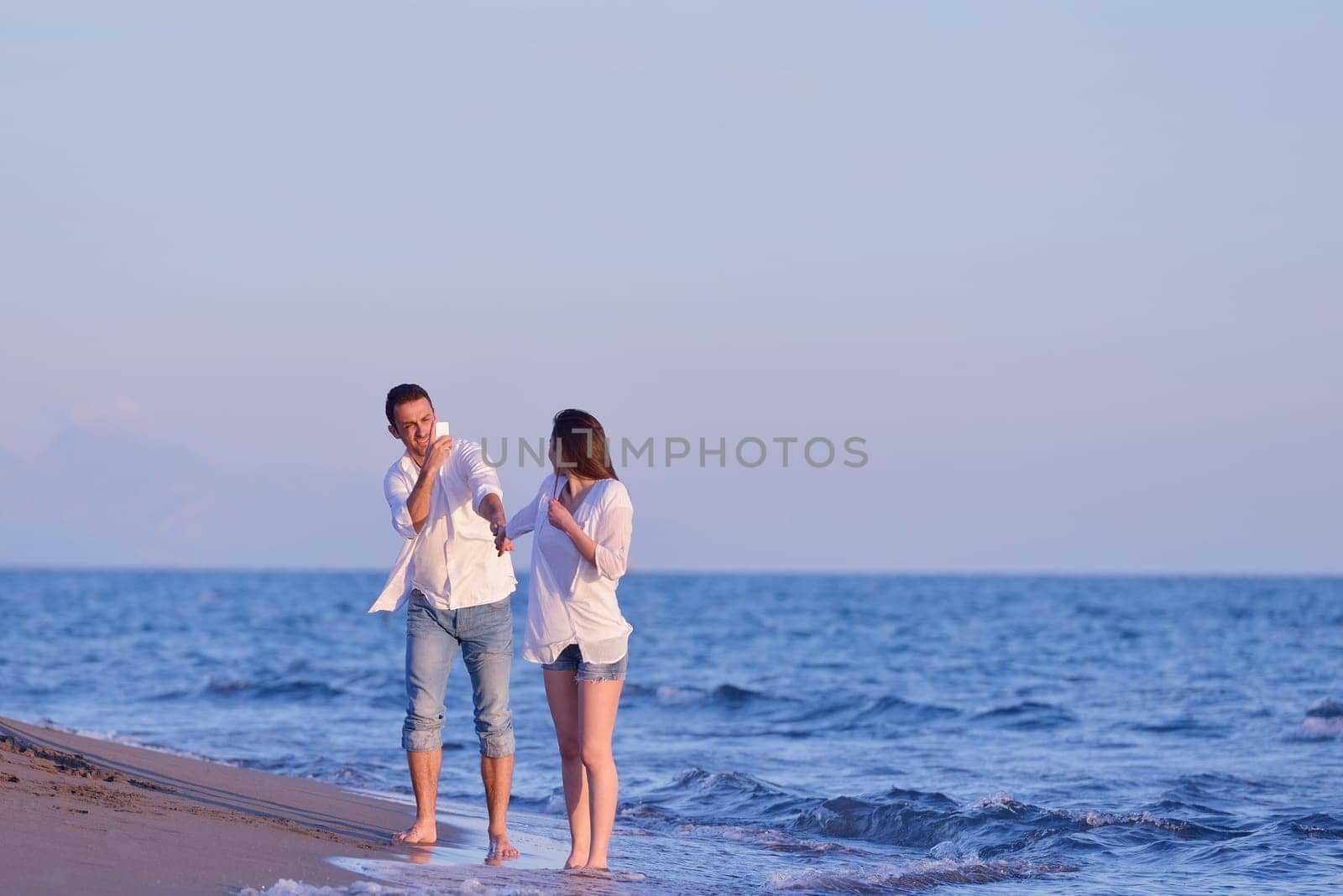 happy young romantic couple in love have fun on beautiful beach at beautiful summer day