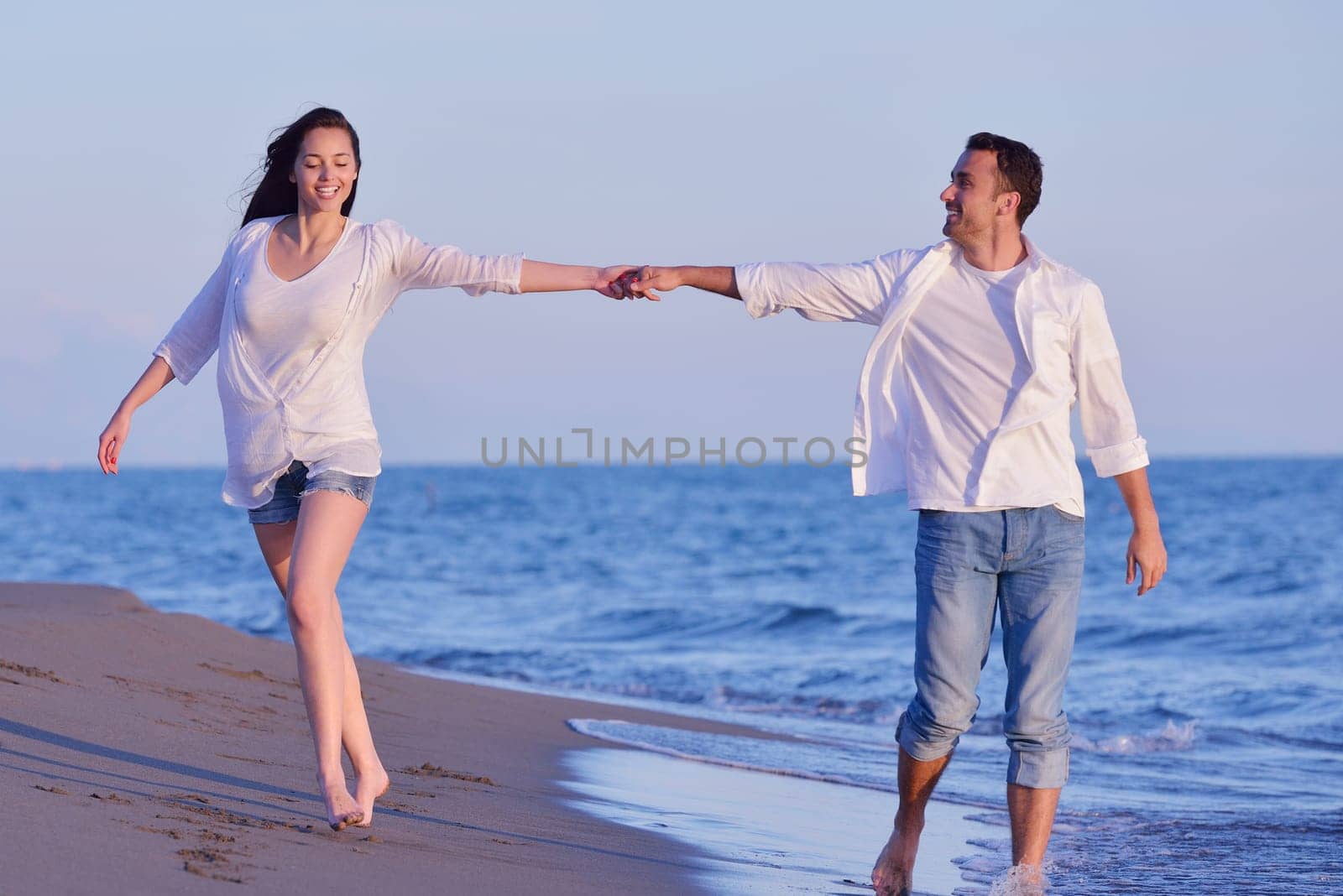 happy young romantic couple in love have fun on beautiful beach at beautiful summer day