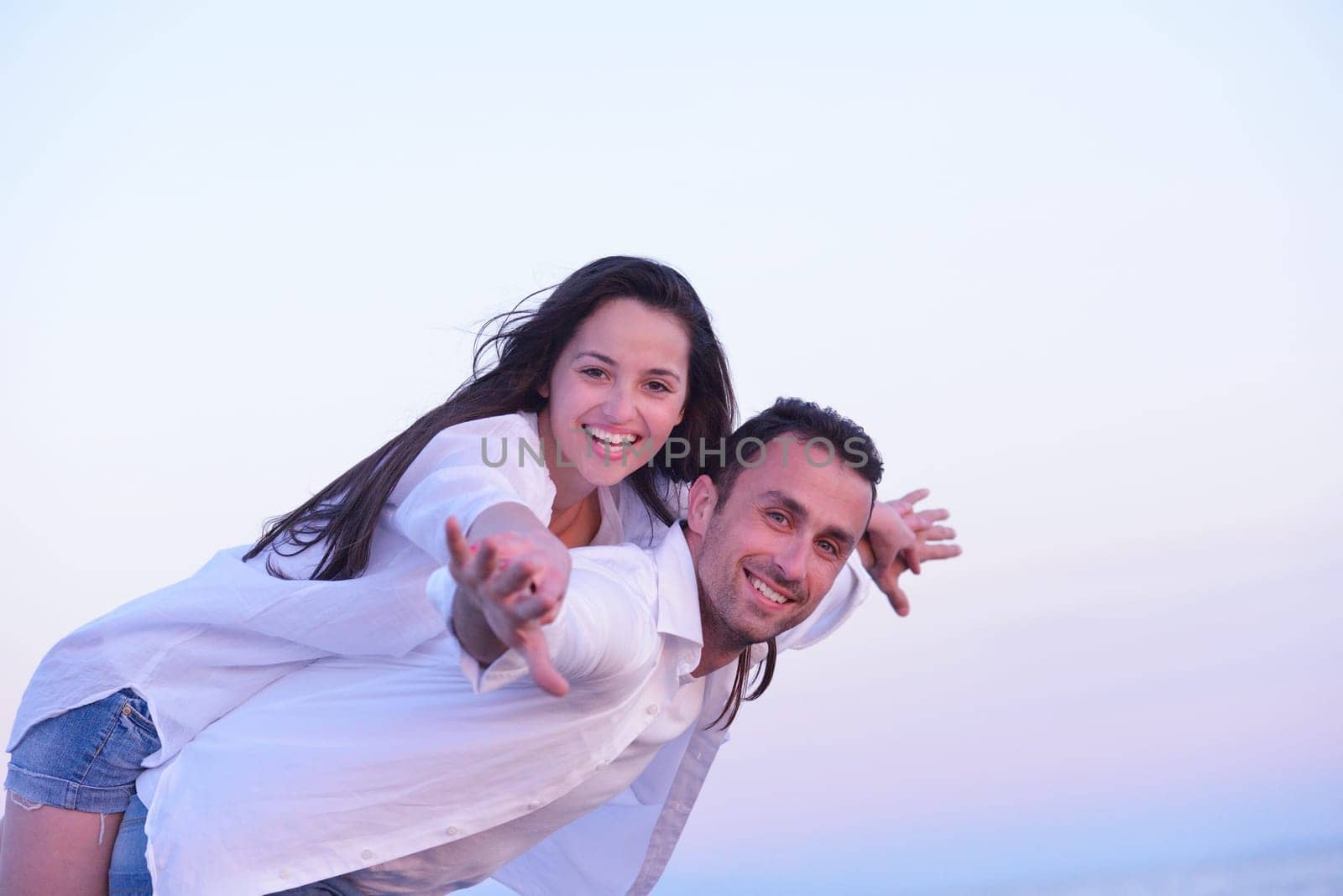happy young romantic couple in love have fun on beautiful beach at beautiful summer day