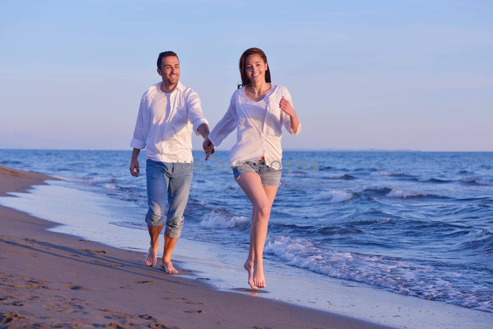 happy young romantic couple in love have fun on beautiful beach at beautiful summer day