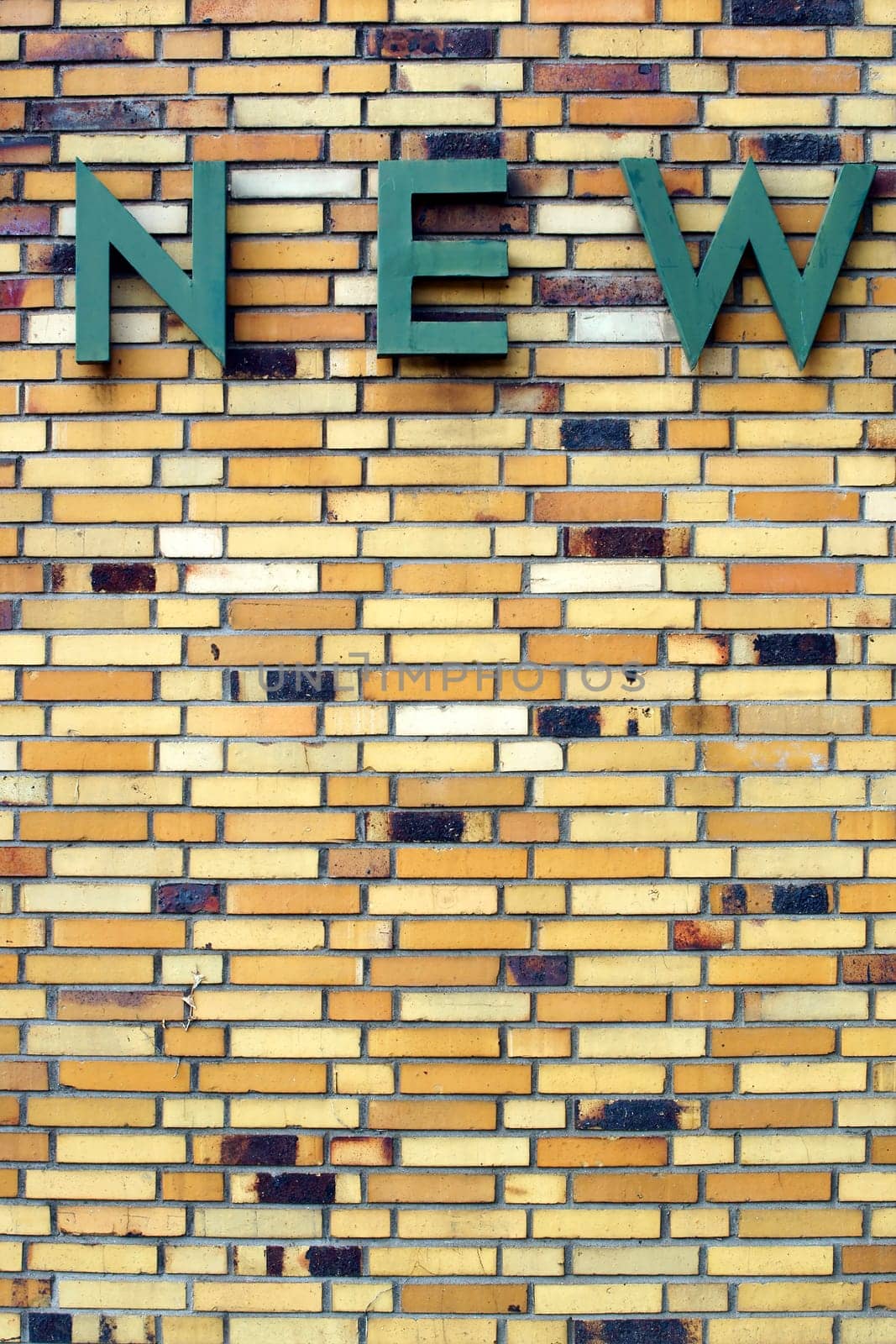The photograph of an old and distinctive brick wall with a sign of single letters.