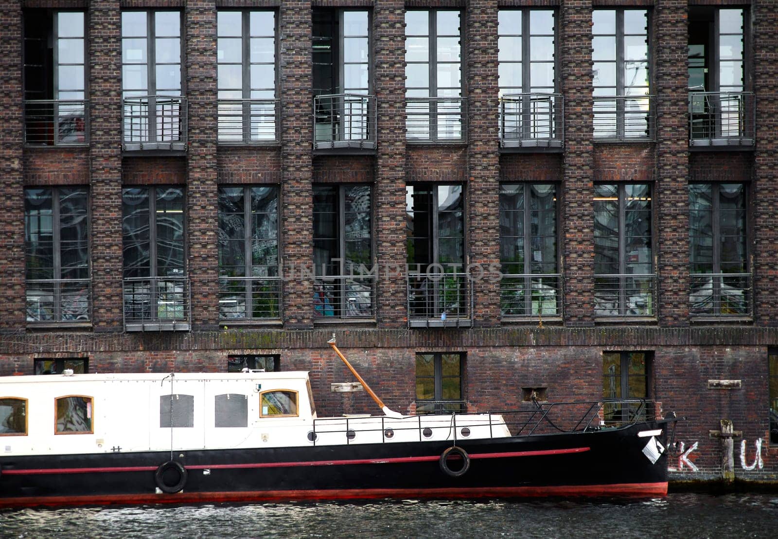 The photograph of an old brick building with offices on the Spree in Berlin.