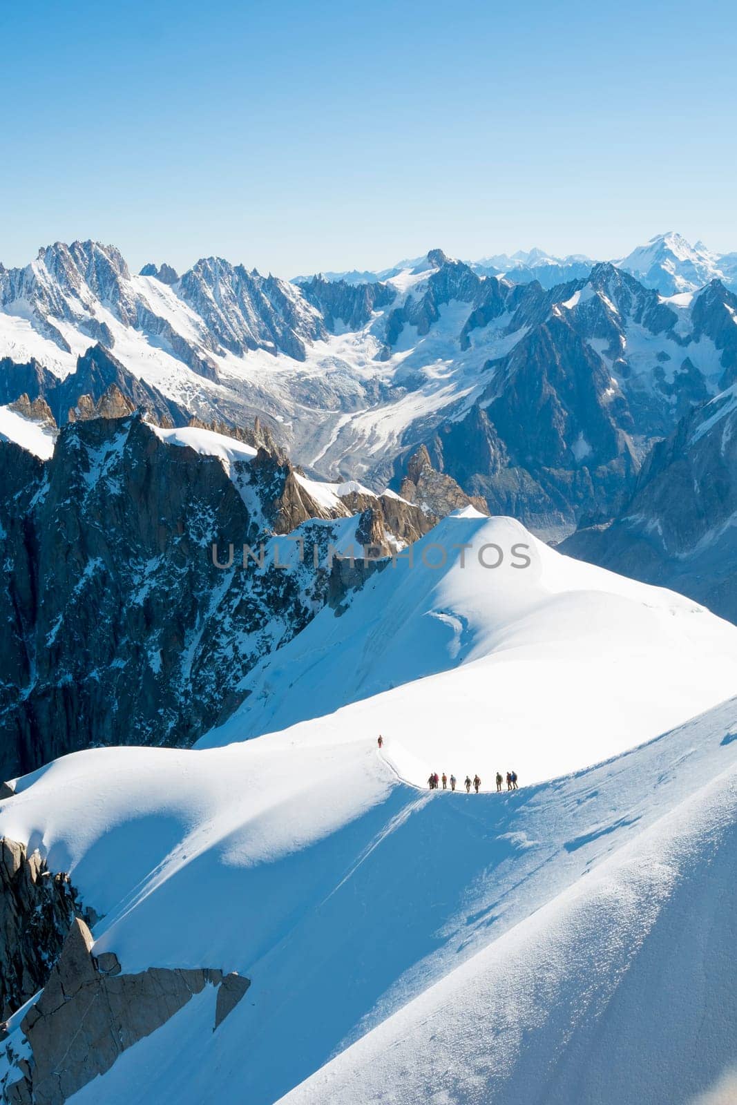 Mont Blanc mountaneers walking on snowy ridge. The mountain is the highest in the alps and the European Union.