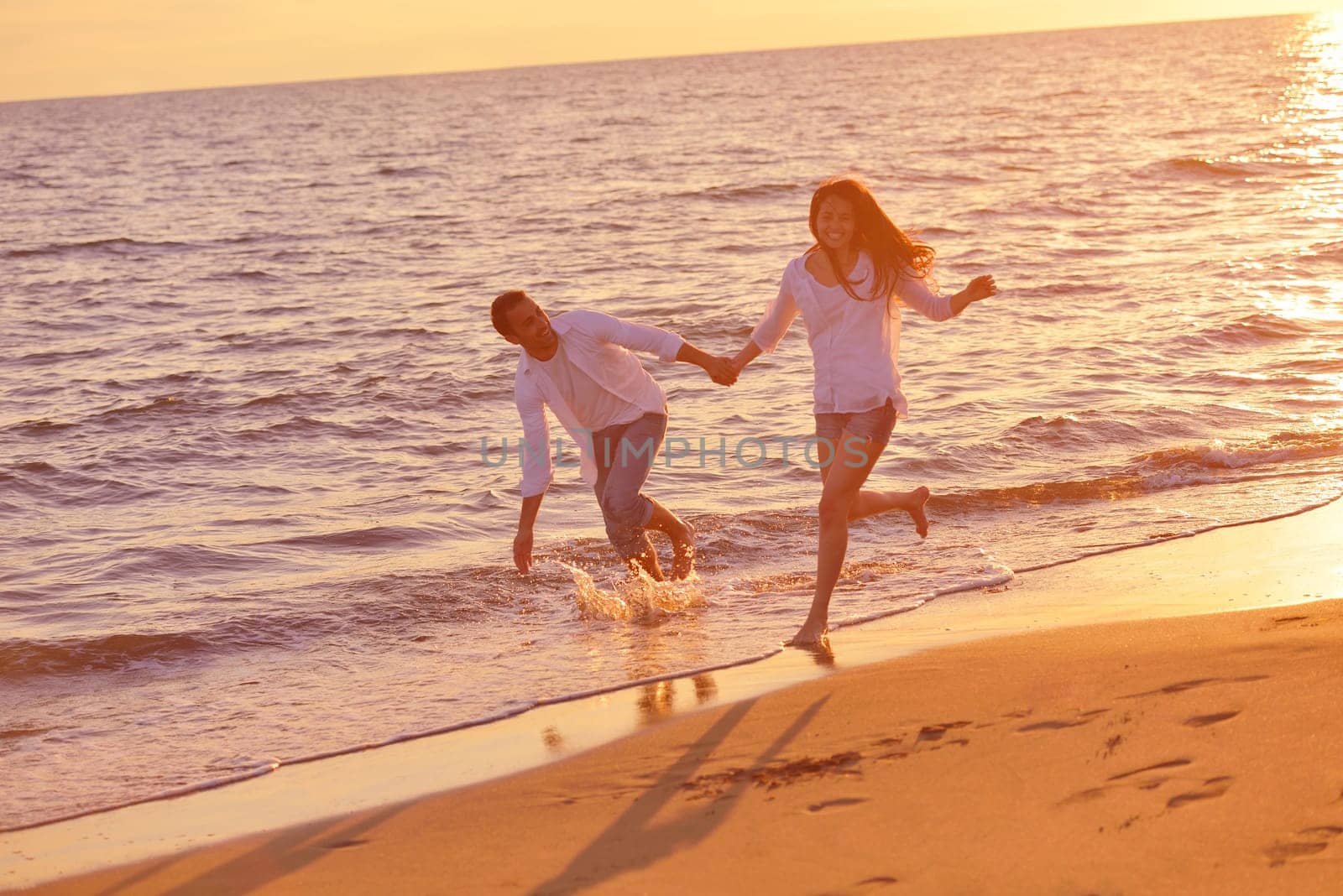 happy young romantic couple in love have fun on beautiful beach at beautiful summer day