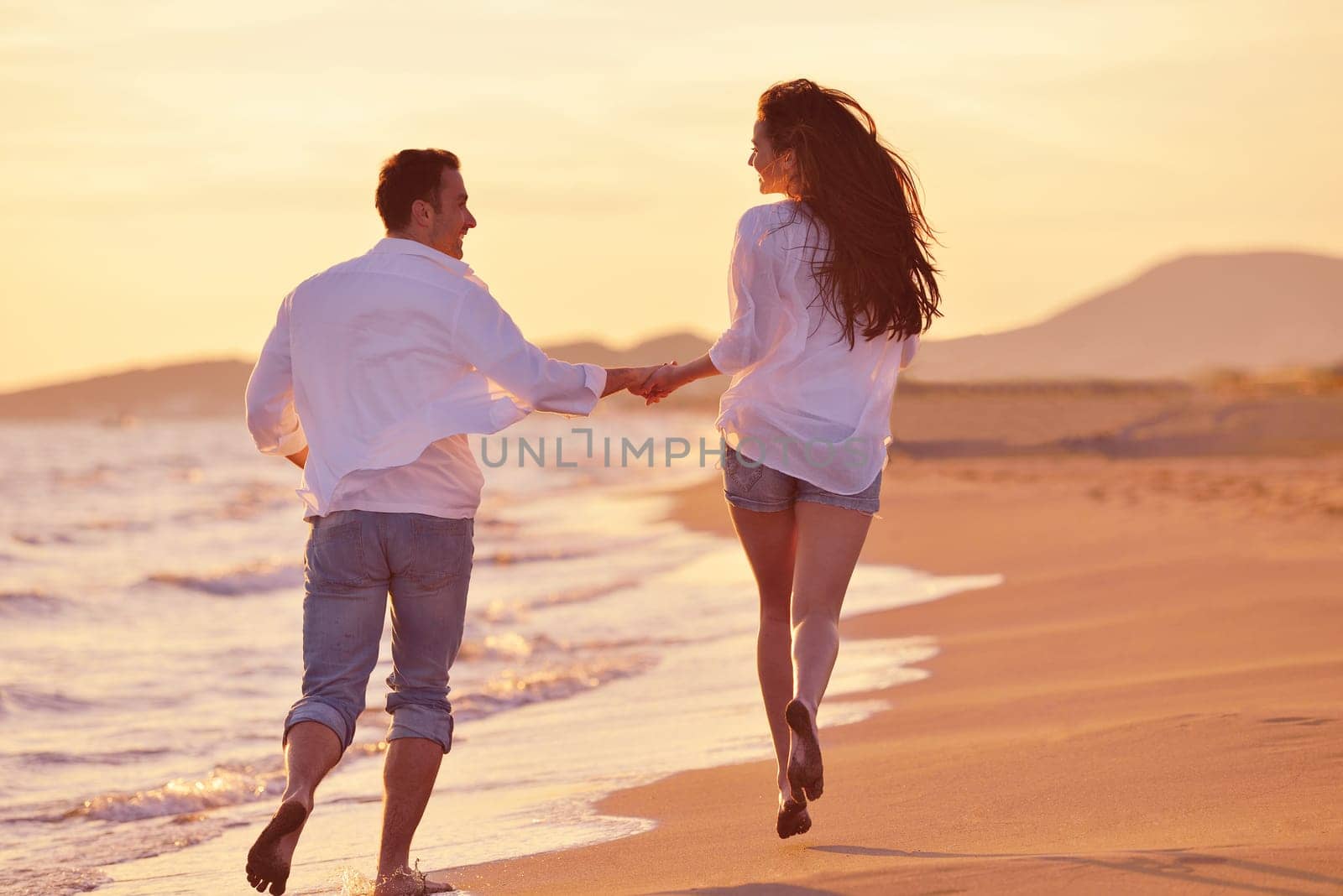 happy young romantic couple in love have fun on beautiful beach at beautiful summer day