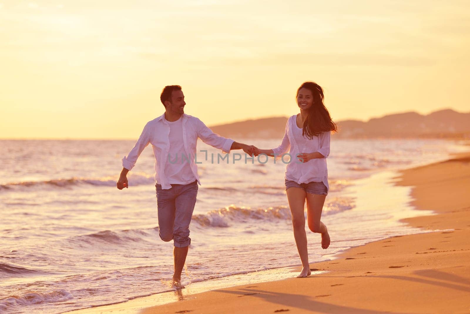 happy young romantic couple in love have fun on beautiful beach at beautiful summer day