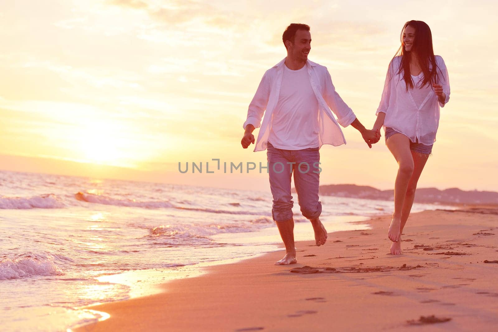 happy young romantic couple in love have fun on beautiful beach at beautiful summer day