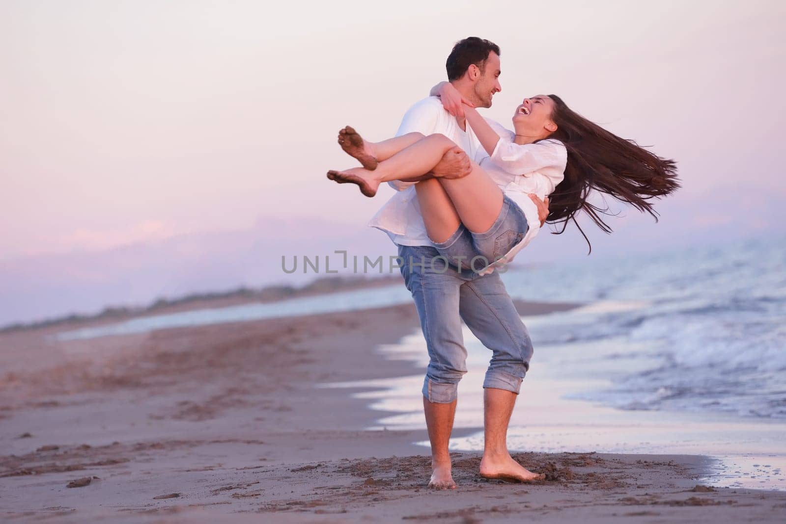 happy young romantic couple in love have fun on beautiful beach at beautiful summer day
