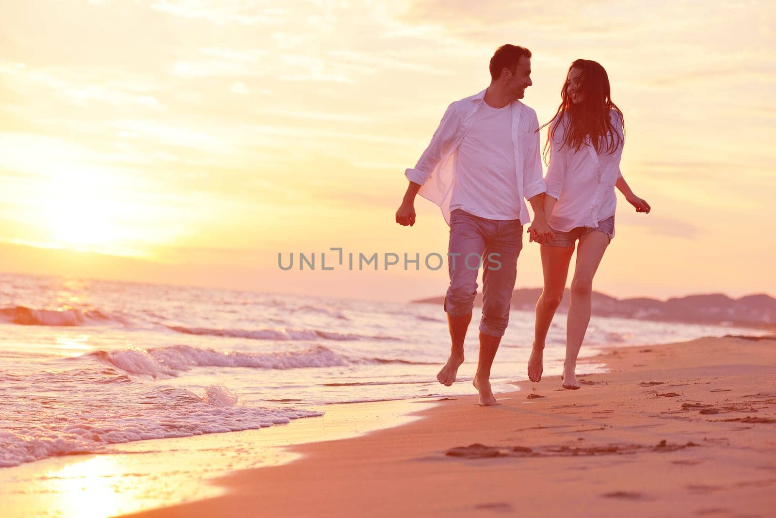happy young romantic couple in love have fun on beautiful beach at beautiful summer day