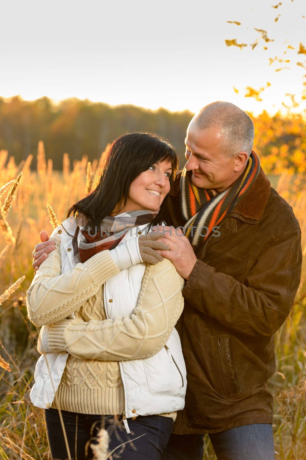 Couple in love hugging sunset autumn countryside looking each other