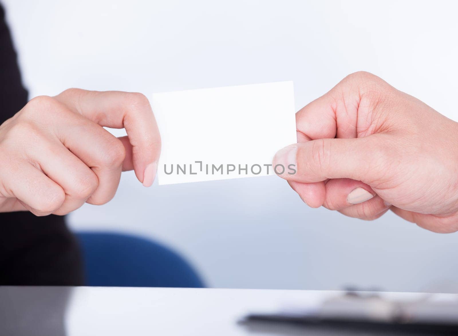 Two Happy Businesspeople Exchanging Visiting Card In Office