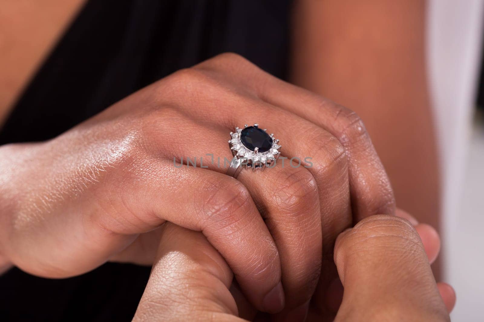 Close Up Of Male Hand Inserting An Engagement Ring Into A Finger