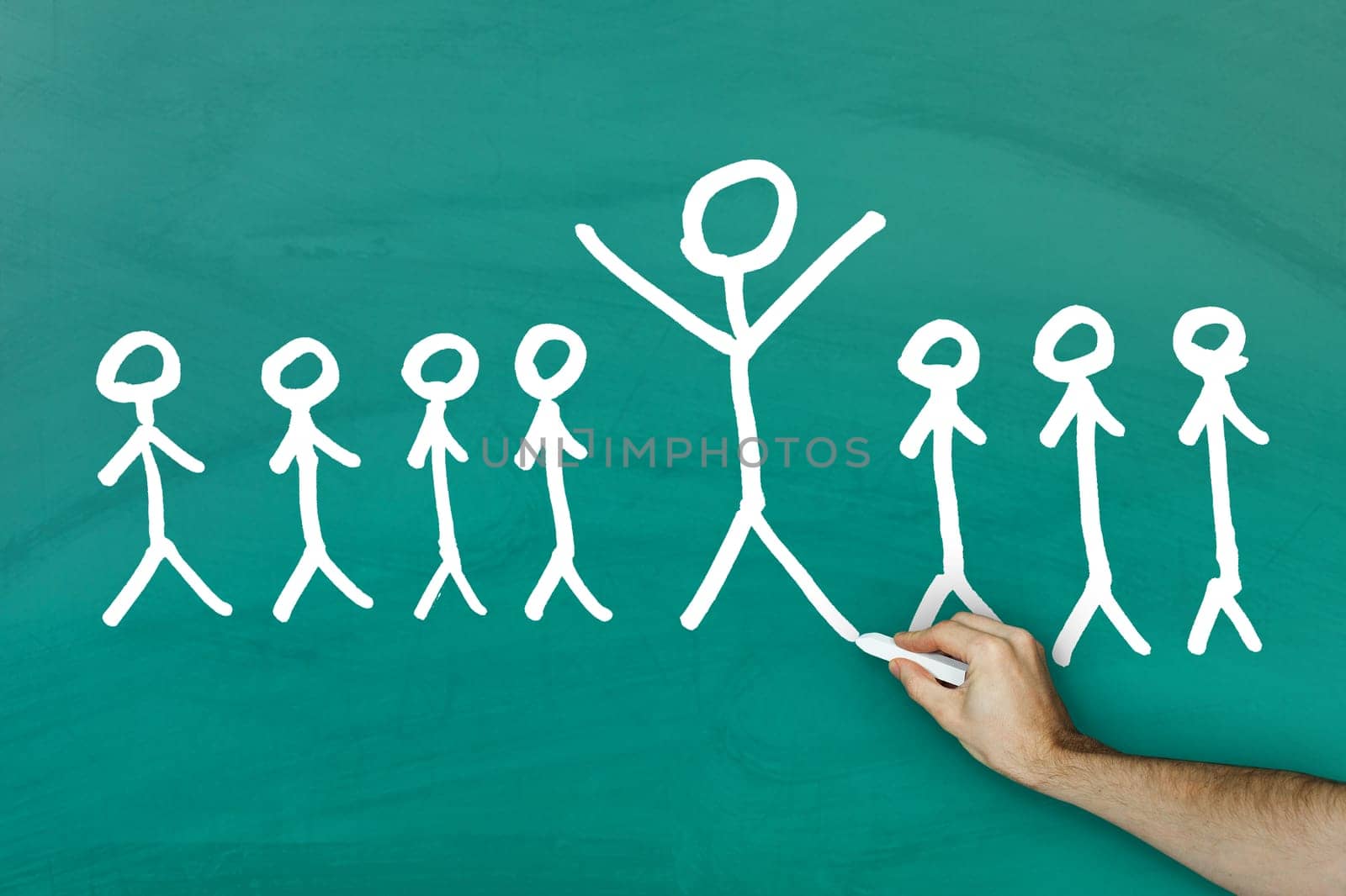 Standing out from crowd concept on green blackboard