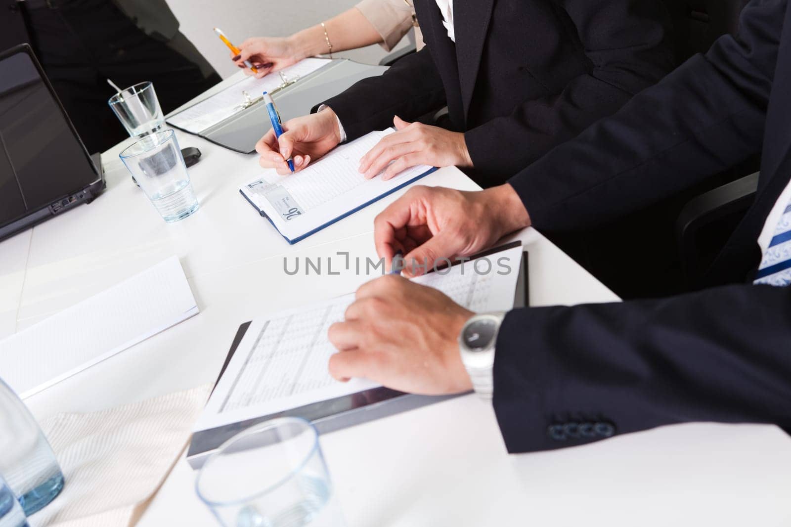 Team of business people taking notes at the meeting