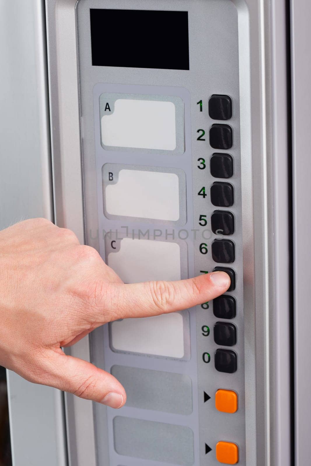 Close-up of hand pressing button of vending machine