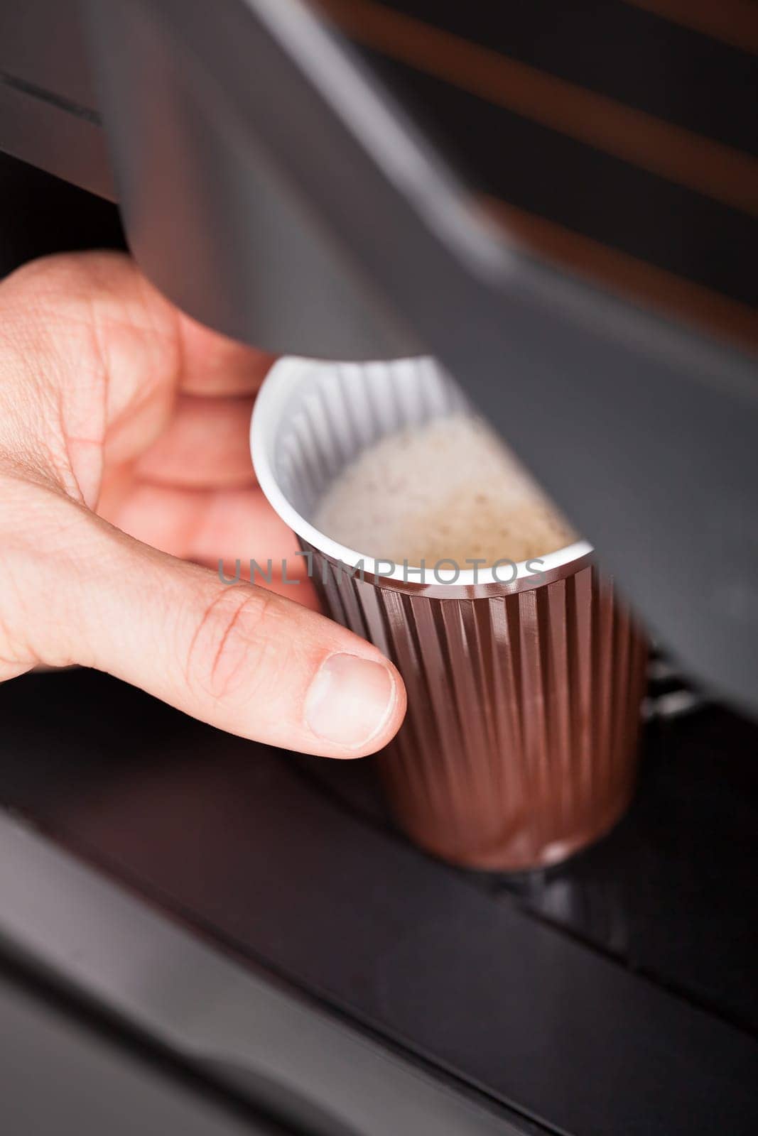 Coffee maker pouring hot espresso coffee in a glass