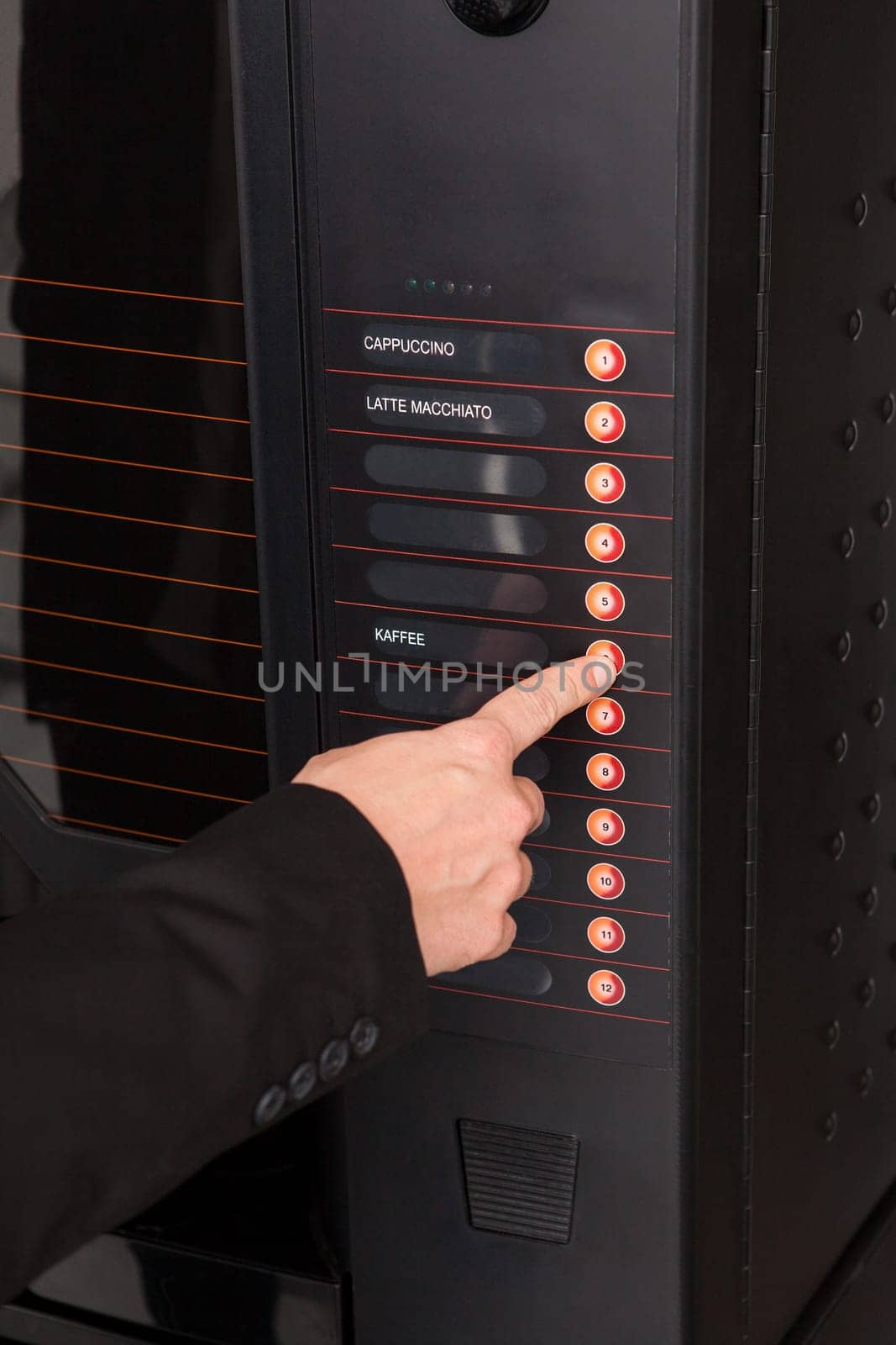 Close-up of hand pressing button of vending machine for coffee