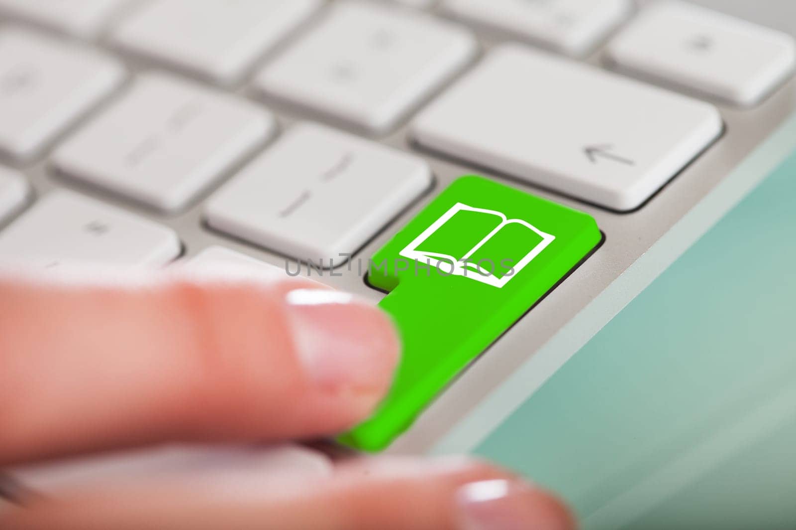 Close-up Of Hand Over Green Key With Book Icon