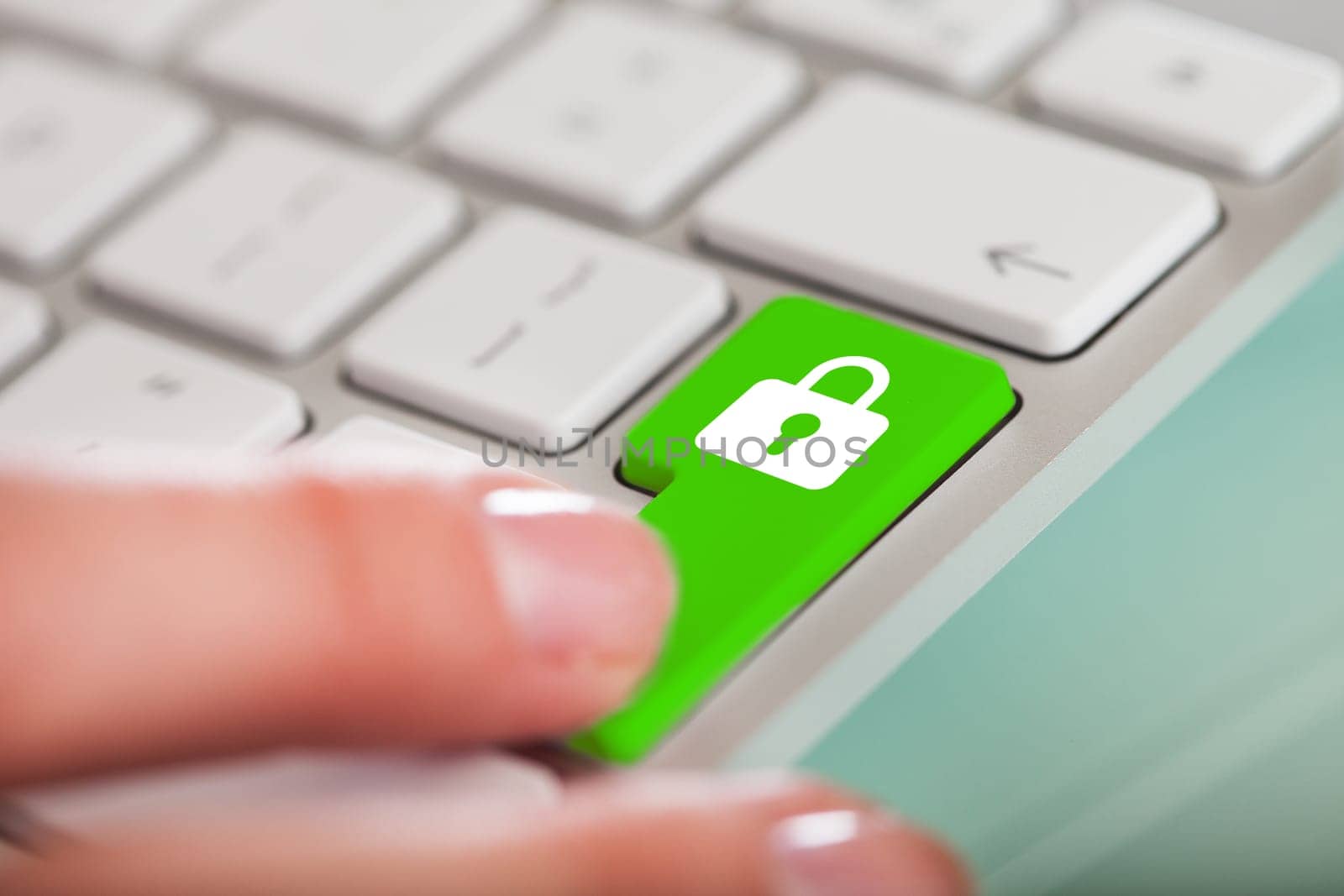 Close-up Of Hand Over Green Key With Lock Sign On Keyboard