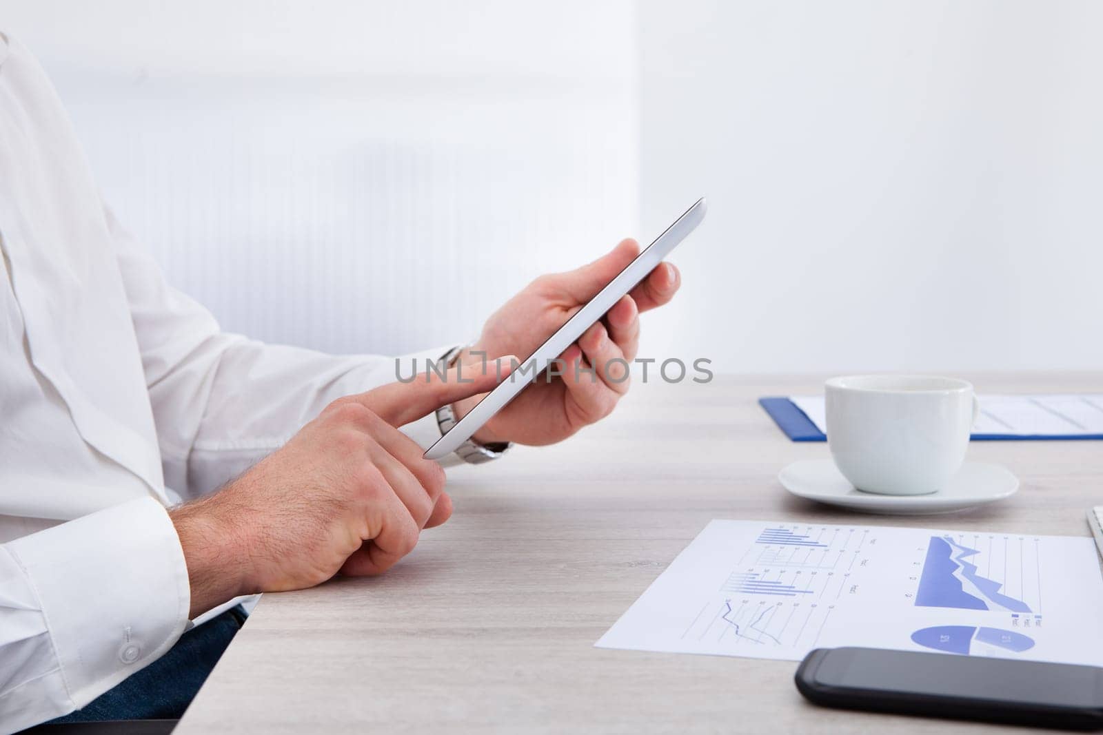 Close-up Of Businessman Hand Using Digital Tablet At Desk