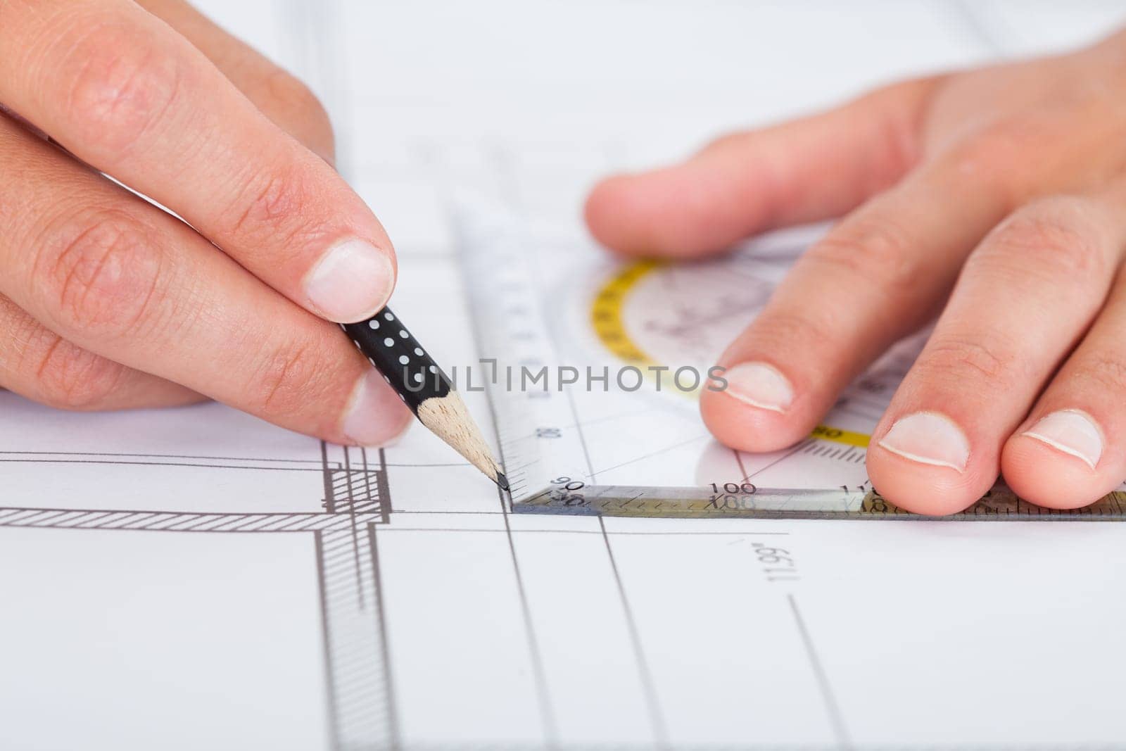 Close-up Of Person's Hand Drawing Plan On Blue Print
