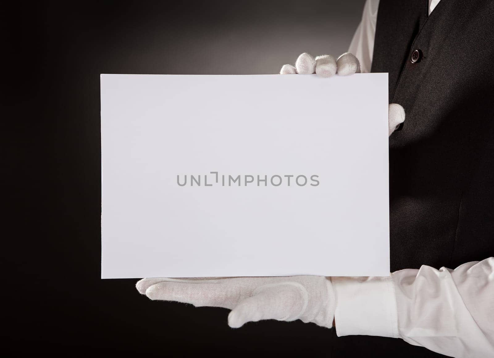 Closeup Of Young Waiter Presenting Blank Placard Over Black Background
