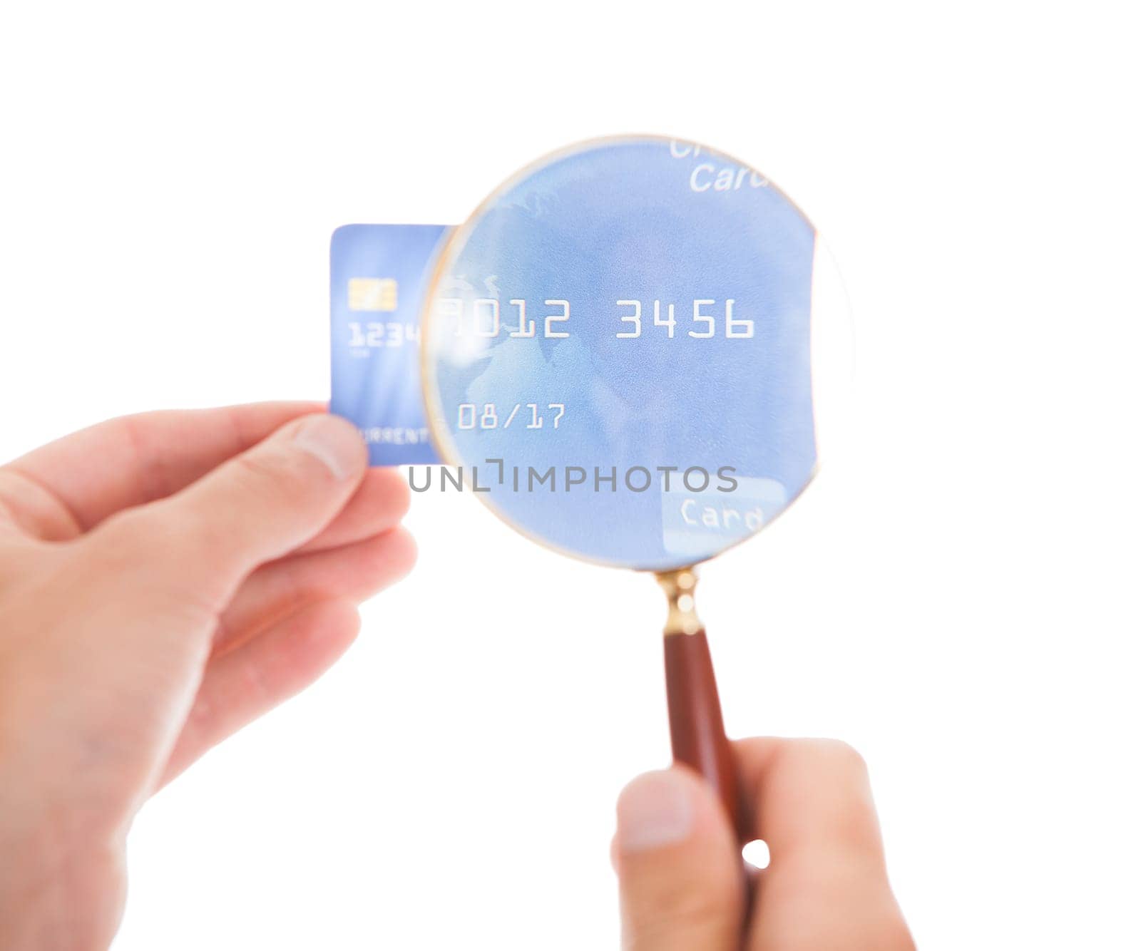 Close-up Of Man Looking At Credit Card Through Magnifying Glass On White Background