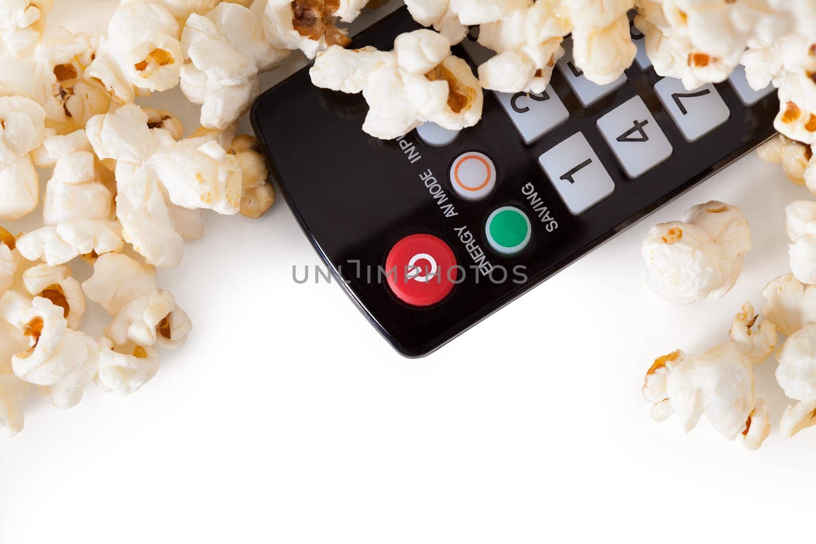 Close-up Of Remote Control And Popcorn Over White Background