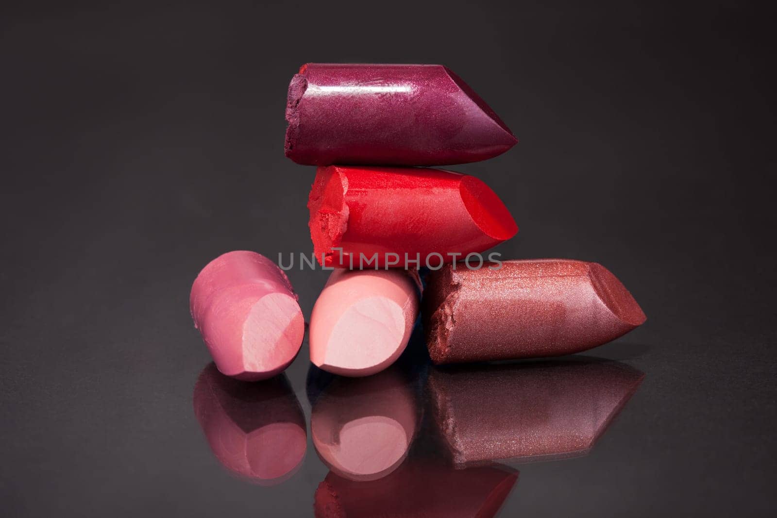 Close-up Of Lipsticks Over Black Reflective Background