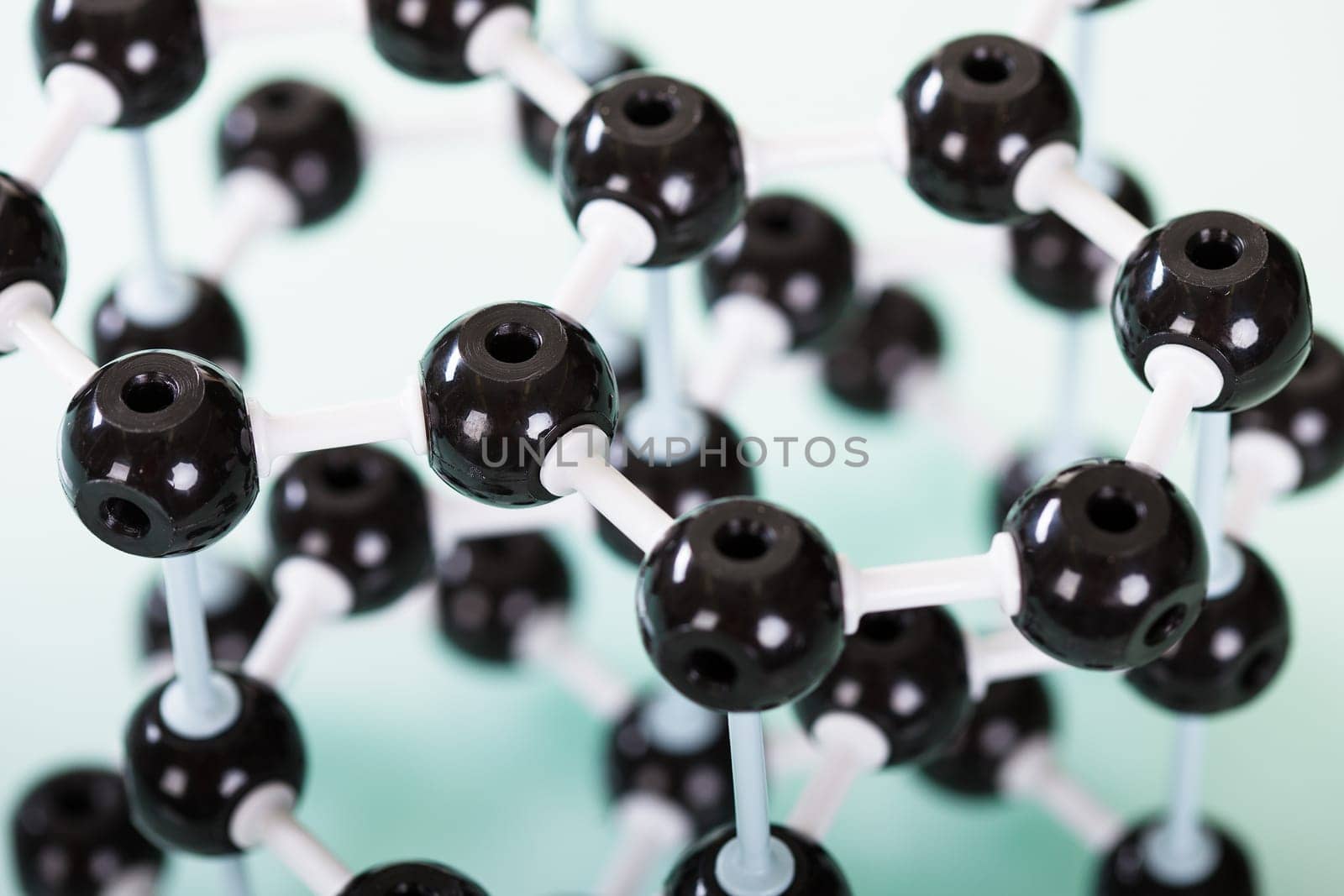Model of graphite molecular structure on green reflective background