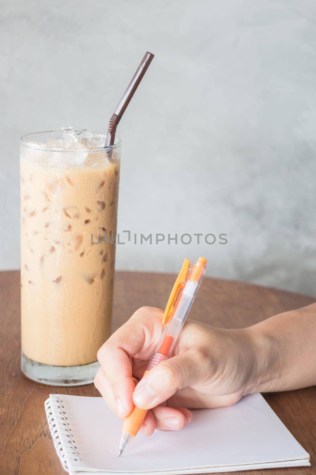 Hand writing on note paper in coffee shop, stock photo