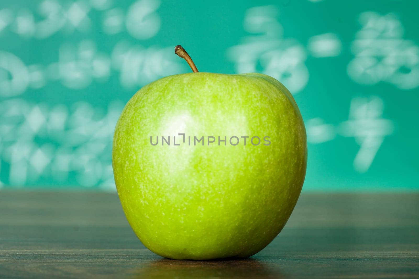 Photo of green apple on the school desk