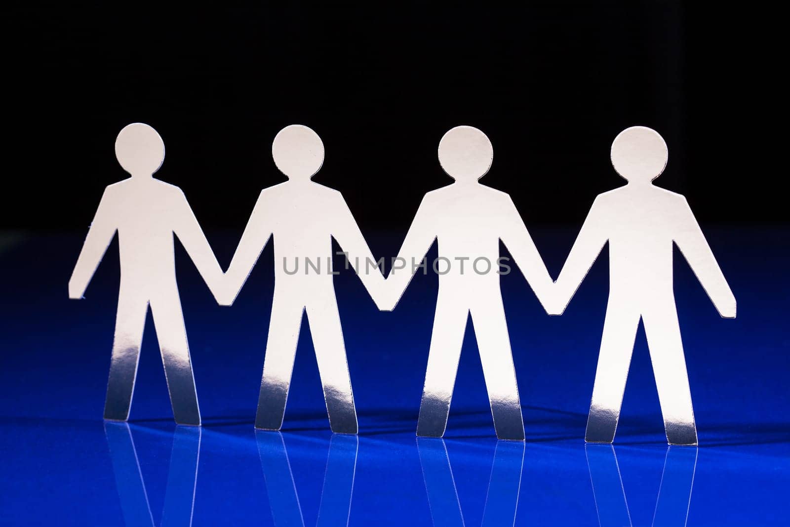 Silhouettes of people holding hands standing next to each other