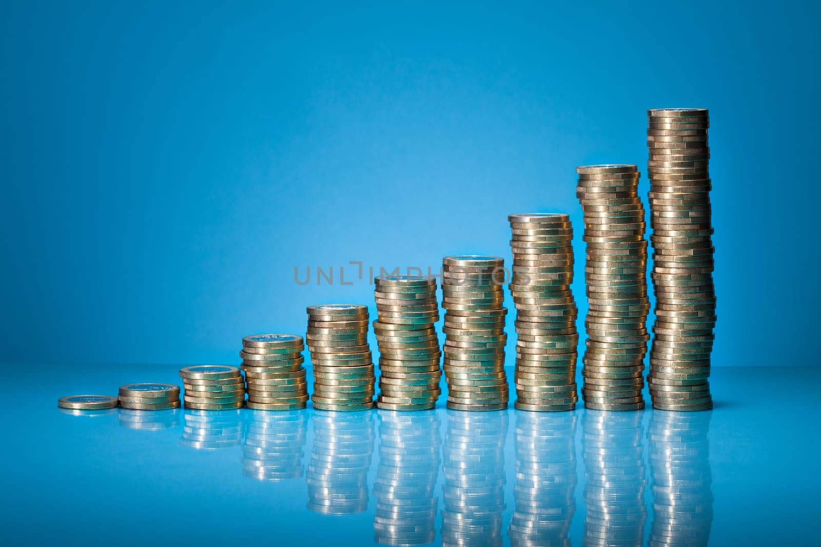 Stack Of One Euro Coins Over Blue Background