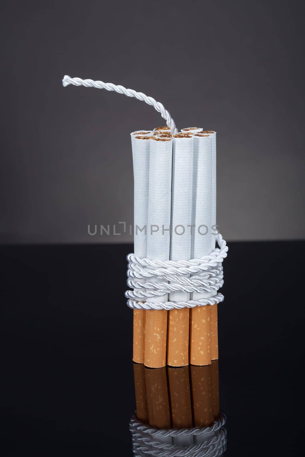 Cigarettes Tied With Rope And Wick Over Blue Background