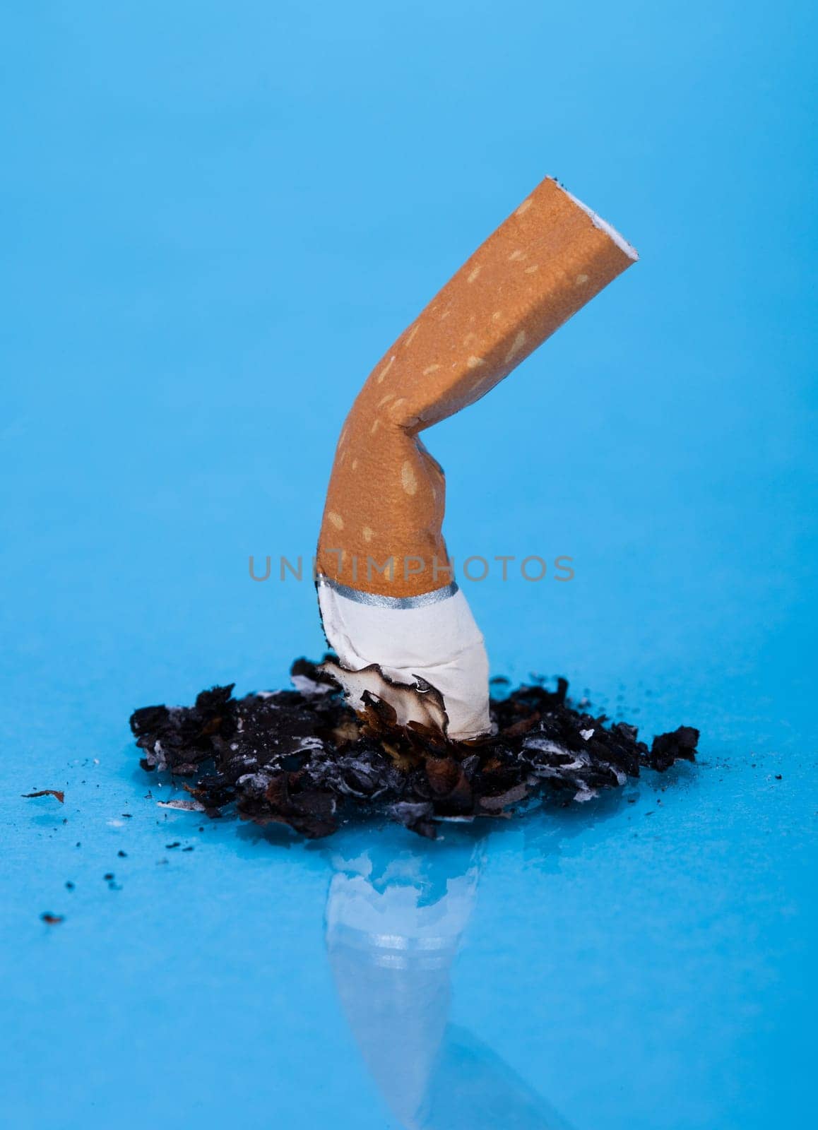 End Of Burning Cigarette Over Blue Background