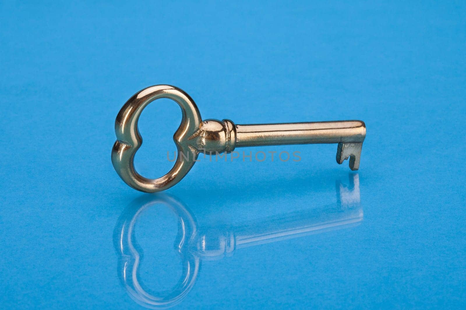 Photo Of Golden Key Isolated Over Blue Background