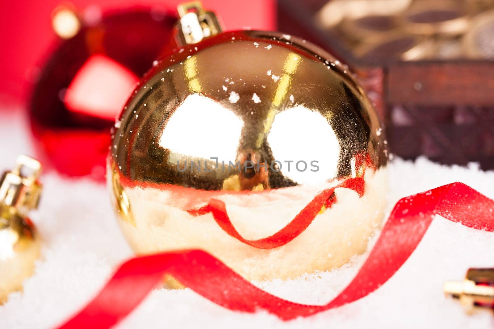 Close-up Of Golden Decorative Christmas Baubles In The Snow