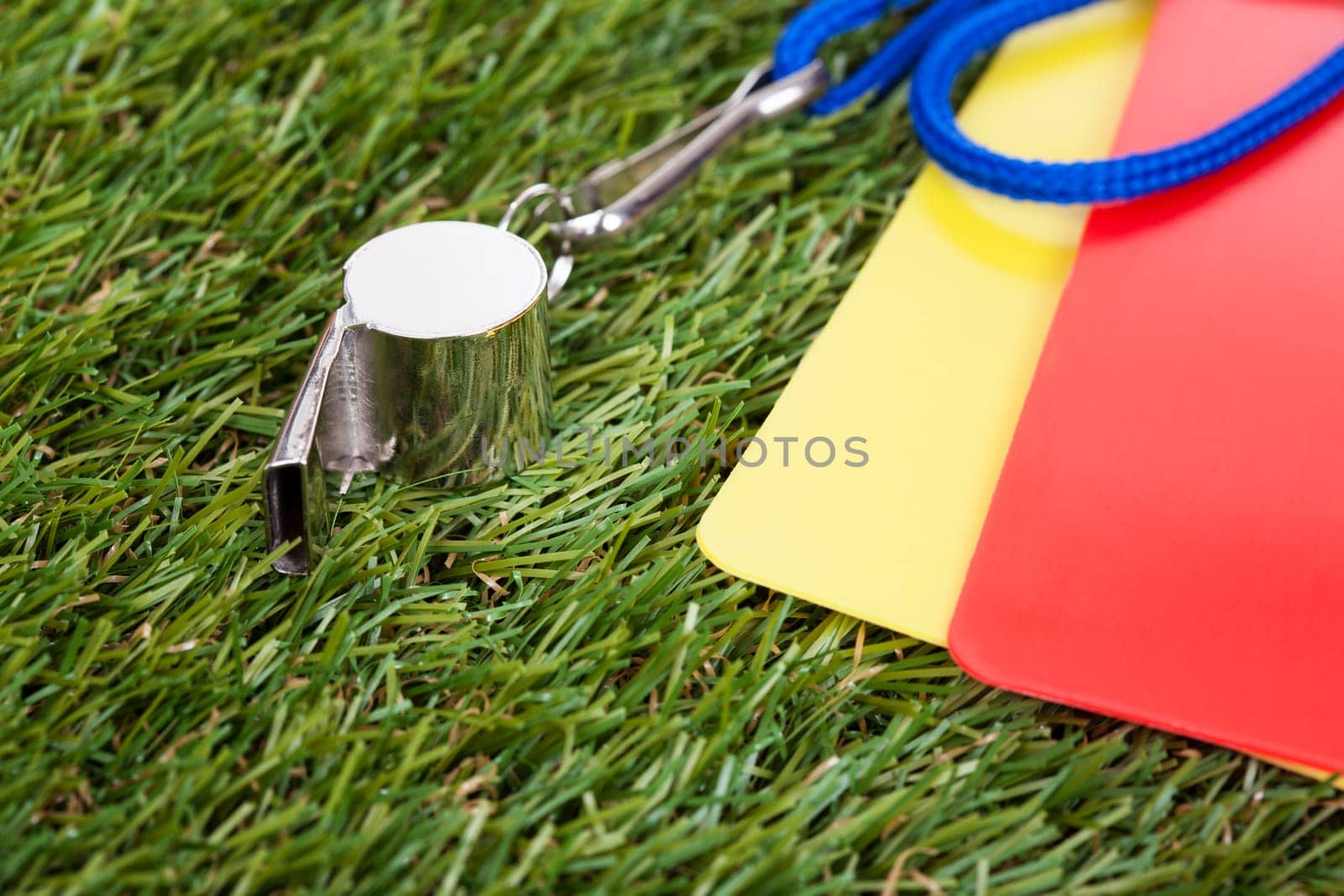 Close-up Of Whistle With Red And Yellow Card On The Field