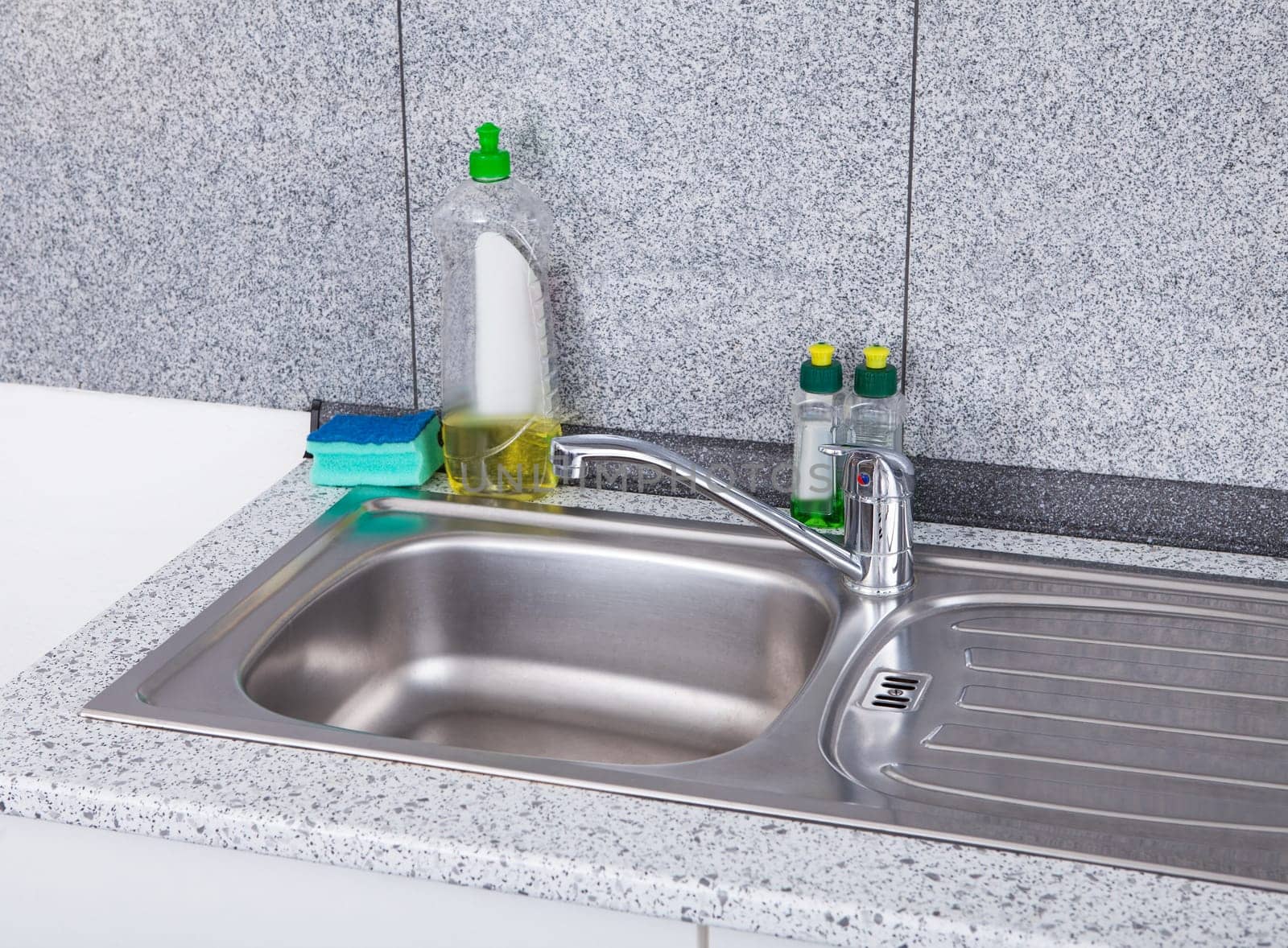 Dishwashing Liquid With Sponge On Silver Kitchen Sink