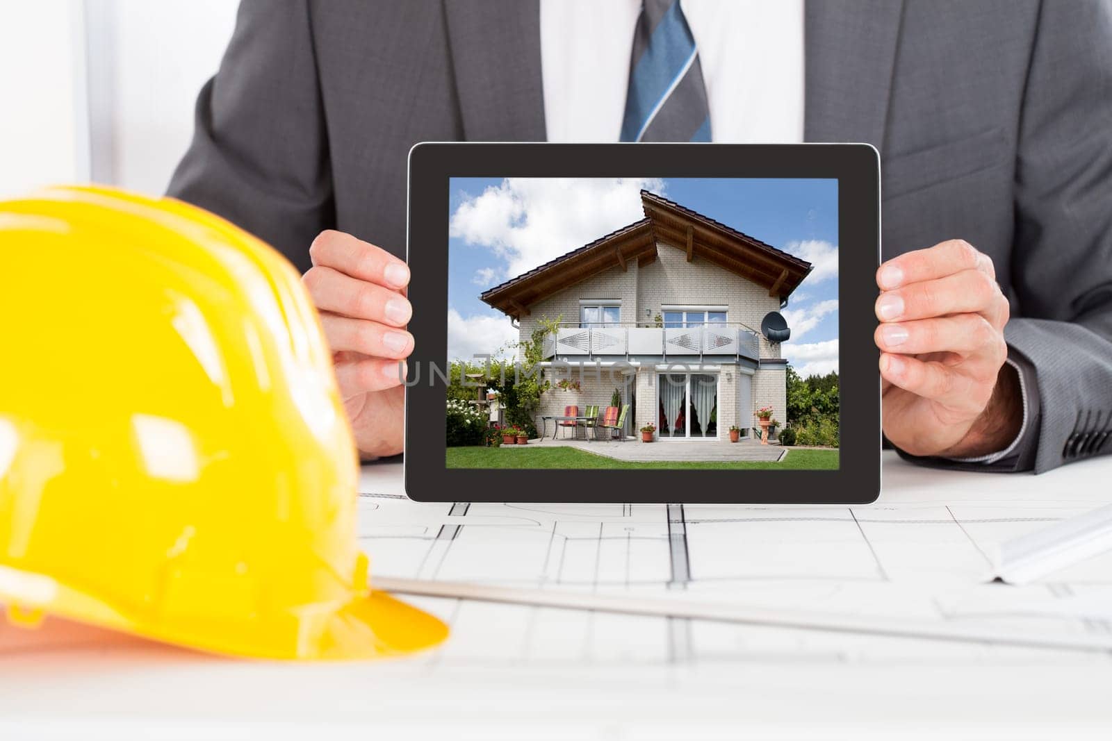 Close-up Of Male Architect Holding Digital Tablet In Front Of Hardhat